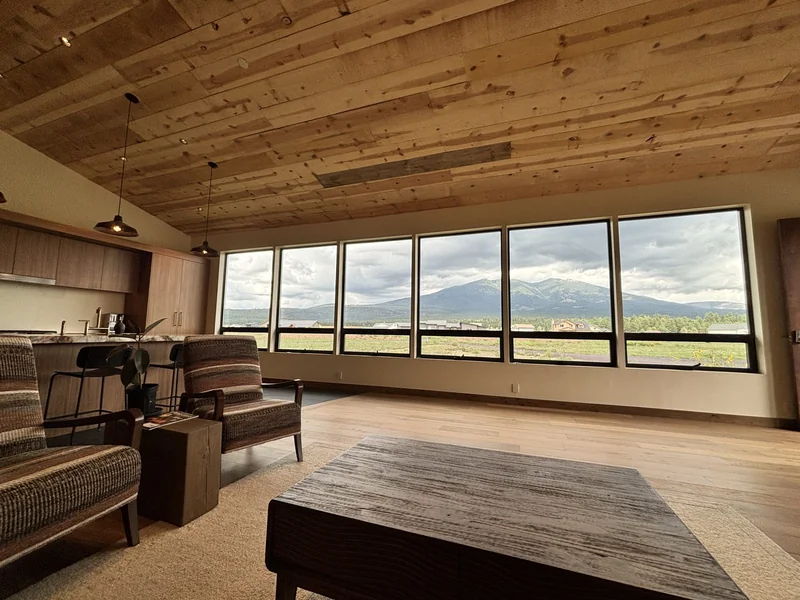 Living room wall of windows framing the San Francisco Peaks