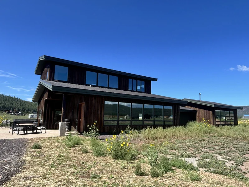 Finished custom home exterior at Kelsey Springs in Flagstaff with dark wood siding and mountain views