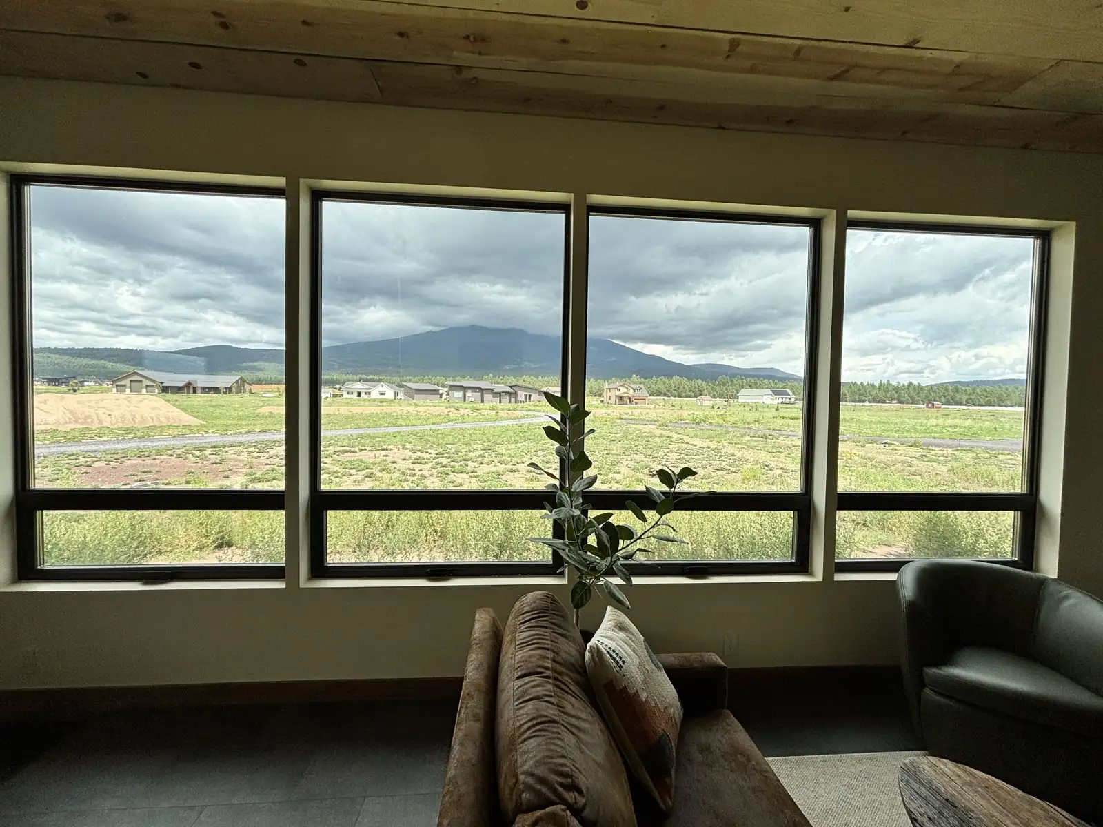 Large window installation with mountain and storm cloud view
