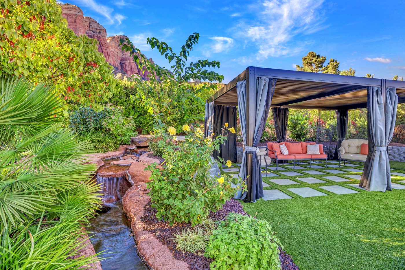Backyard pond and waterfall feature built into a Sedona remodel, with red rock views