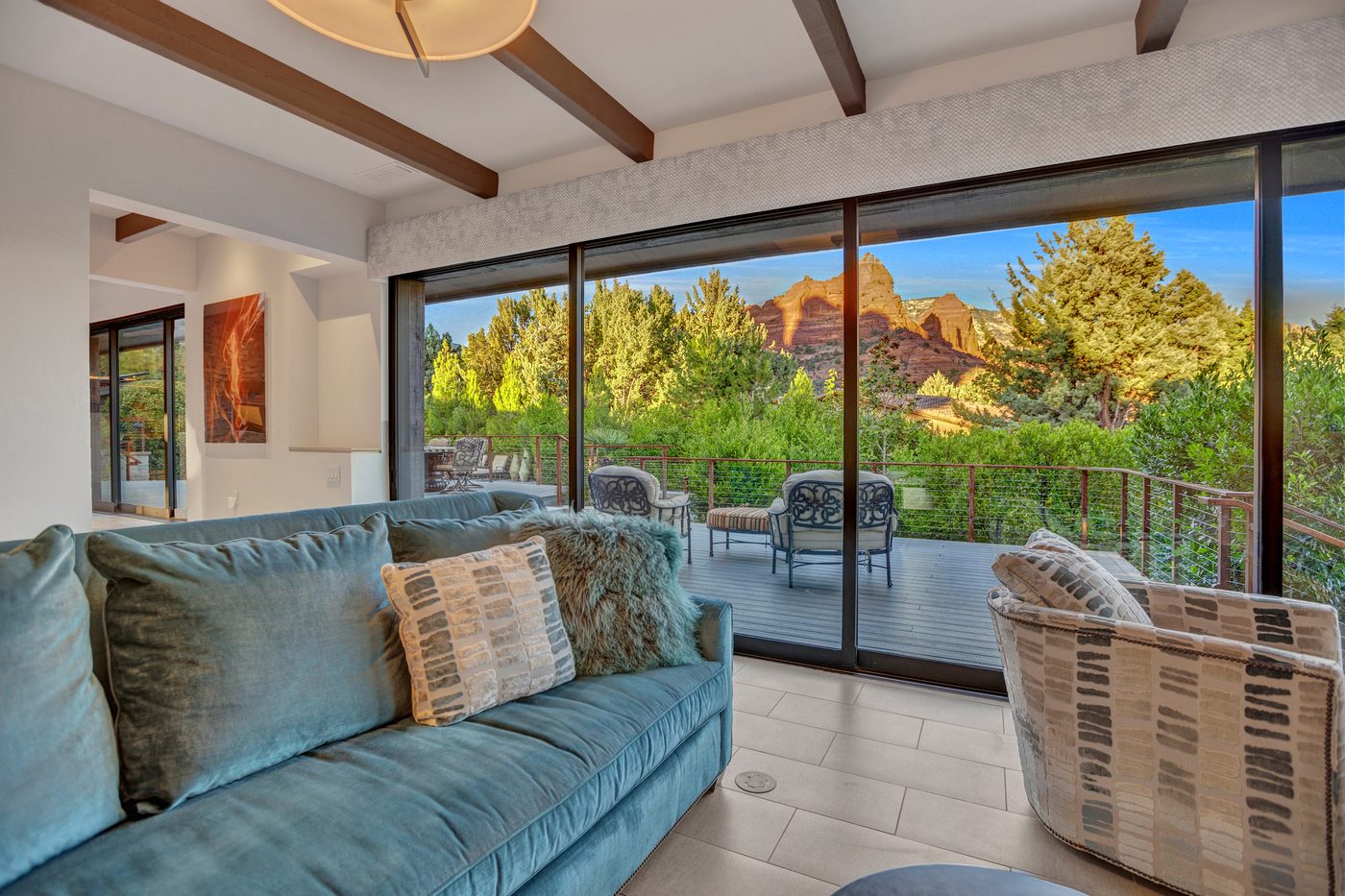 Living room with large multi slide window wall looking out at Sedona red rocks