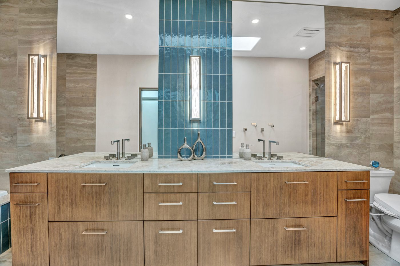 Luxury double vanity bathroom remodel with blue tile accent and stone countertop