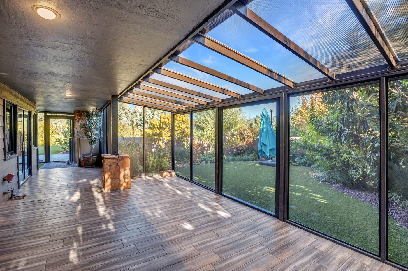 Covered glass walkway with full height windows overlooking a Sedona backyard